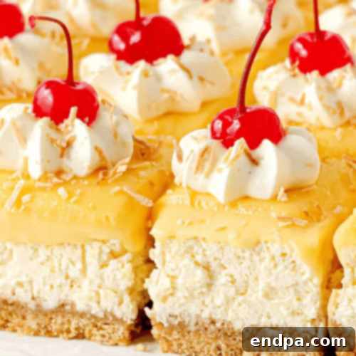 Bite-sized Pina Colada Cheesecake Bites, topped with whipped cream, toasted coconut, and a cherry.