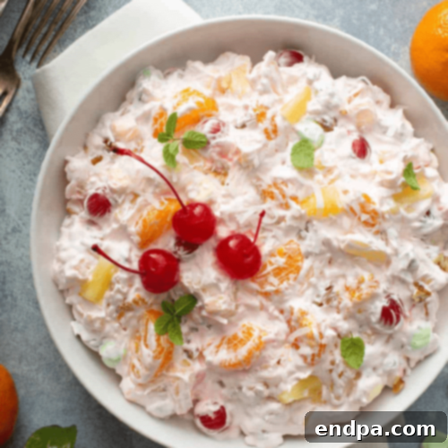 A classic Ambrosia Salad, rich with pineapple, mandarin oranges, coconut, and miniature marshmallows.