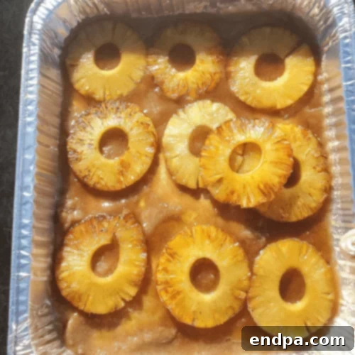 Grilled pineapple slices infused with Fireball whiskey, showing grill marks and a glossy finish.