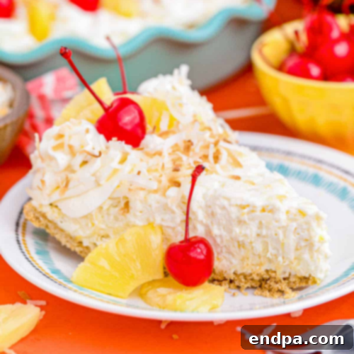 A no-bake Pina Colada Pie with a graham cracker crust, creamy filling, and whipped cream topping.