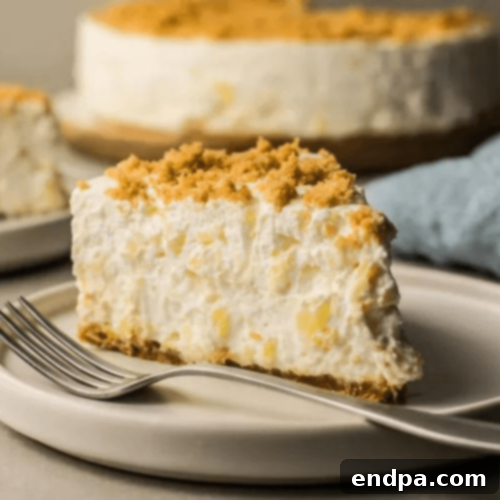 A creamy No-Bake Pineapple Cheesecake in a graham cracker crust, topped with fresh pineapple chunks.