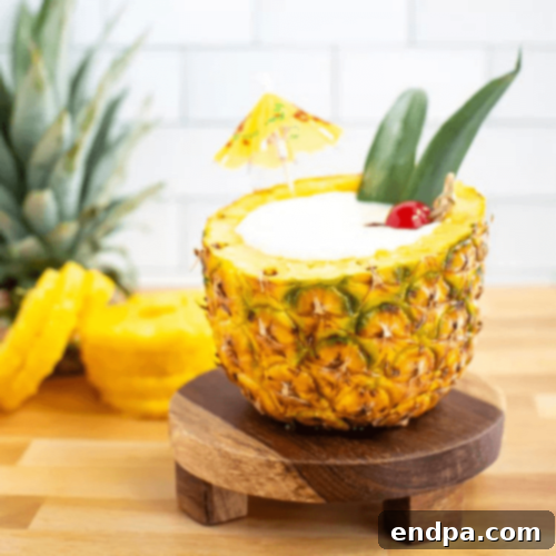 A refreshing Pina Colada cocktail served creatively inside a hollowed-out fresh pineapple.