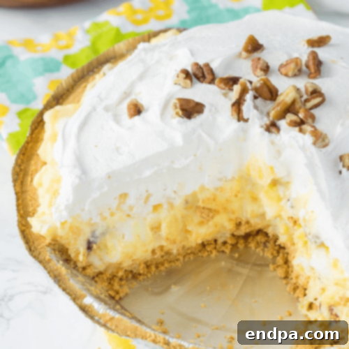 A creamy, fluffy Pineapple Fluff Pie with a golden crust, ready to be served.