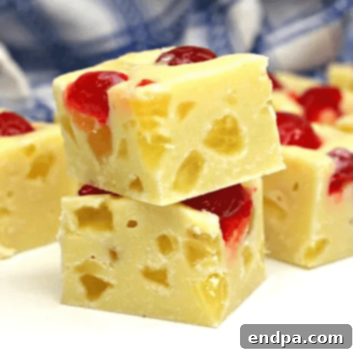 Squares of Pineapple Upside Down Cake Fudge, featuring candied pineapple and cherries.