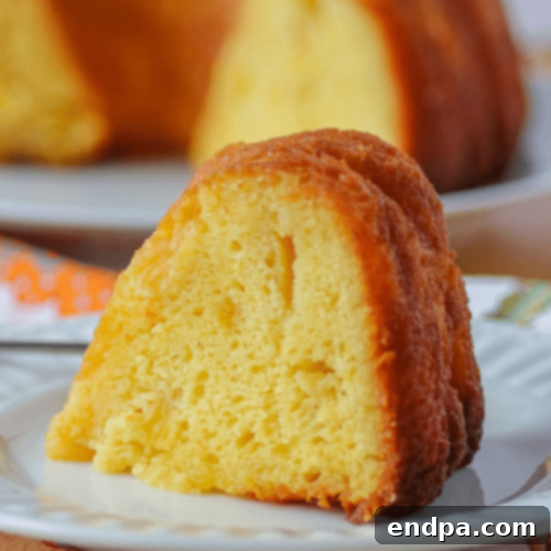 A decadent Pineapple Rum Cake, glazed and garnished with pineapple pieces.