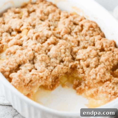 A bubbling Fresh Pineapple Crisp with a golden, crumbly topping, served warm.