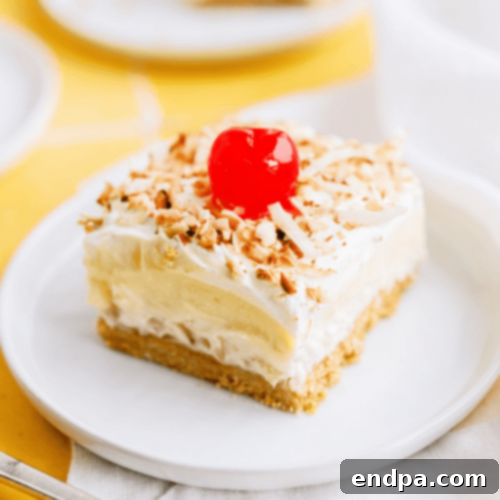 A vibrant Layered Pina Colada Dessert, showcasing perfect layers of pineapple, coconut, and cherry flavors.