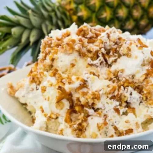 A cool, creamy Pineapple Pretzel Fluff with salty, crunchy pretzel bits mixed in.
