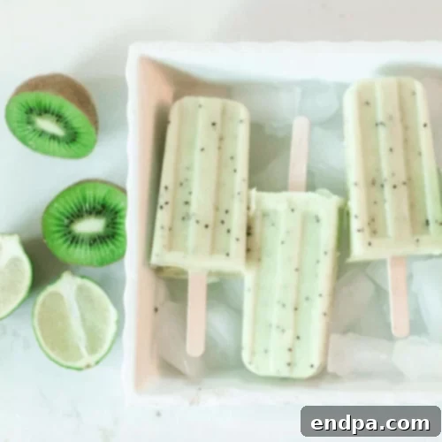 The Ultimate Collection of Tangy Lime Desserts 52 Bright green kiwi lime popsicles with visible kiwi seeds, in a glass.