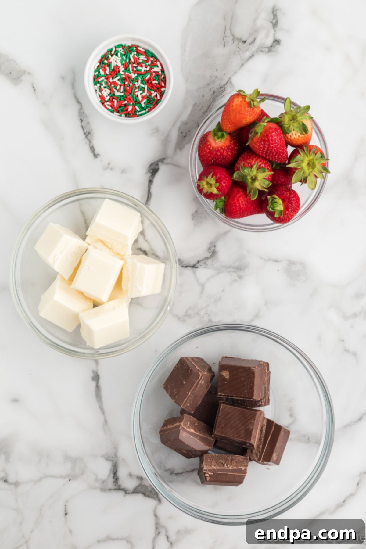 Yuletide Chocolate Strawberries 3 Ingredients for Christmas Chocolate Covered Strawberries: fresh strawberries, chocolate almond bark, white chocolate almond bark, and an assortment of festive Christmas sprinkles.