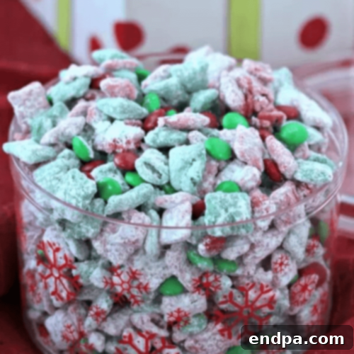 Festive Christmas Puppy Chow with powdered sugar and colorful candies.