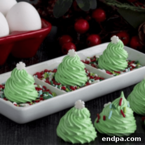 Delicate Christmas Tree Meringue Cookies, decorated with festive sprinkles.