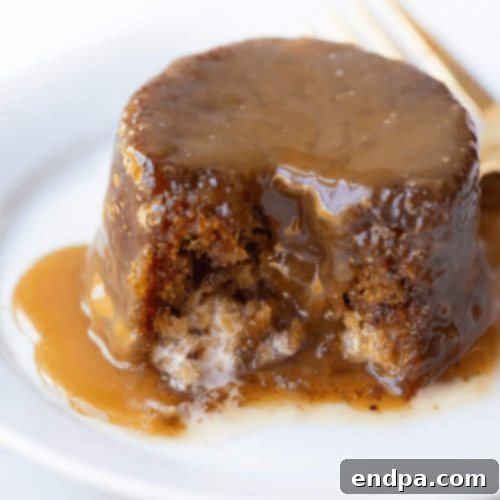 A slice of Gluten Free Sticky Toffee Pudding Cake with sauce.