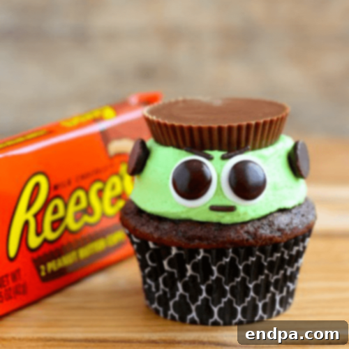 Playful Reese’s Frankenstein Cupcakes featuring green frosting, candy eyes, and a Reese’s Cup for the monster's head.
