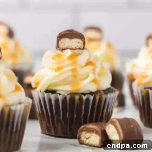 Decadent Homemade Twix Bars Cupcakes featuring a chocolate base, caramel filling, and a chocolate drizzle.