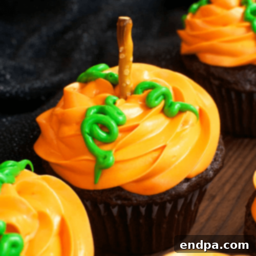 Creative Pumpkin Patch Cupcakes featuring orange frosting, pretzel stems, and green leaf candy decorations.