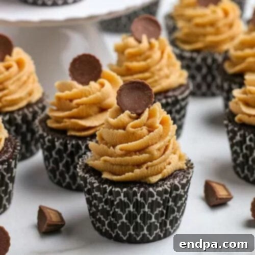 Decadent Chocolate Peanut Butter Cupcakes with a generous swirl of peanut butter frosting and chocolate shavings.