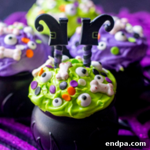 Whimsical Witch Cauldron Halloween Cupcakes presented in edible cauldron cups with green 'potion' frosting and sprinkles.