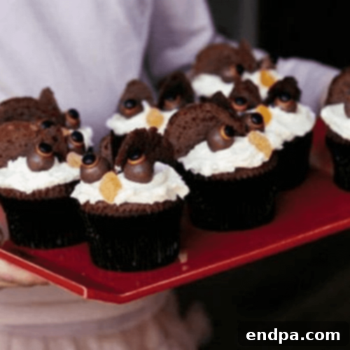 Cute Hooting Halloween Owls Cupcakes adorned with chocolate frosting, Oreo eyes, and candy corn beaks.