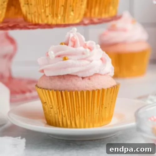 Elegant Pink Champagne Cupcakes topped with a swirl of pink buttercream frosting and delicate sprinkles.
