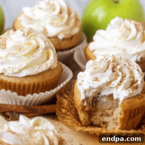 Cozy Apple Pie Cupcakes stuffed with apple pie filling and topped with a light whipped topping.