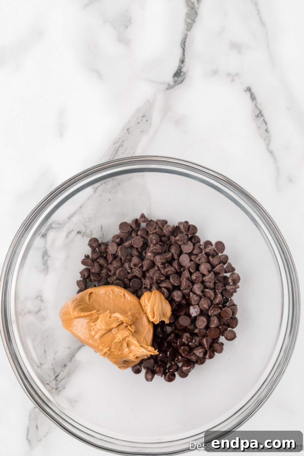 Smores Indulgence Mix 4 Microwave-safe bowl with chocolate chips, peanut butter, and vanilla extract ready to be melted.