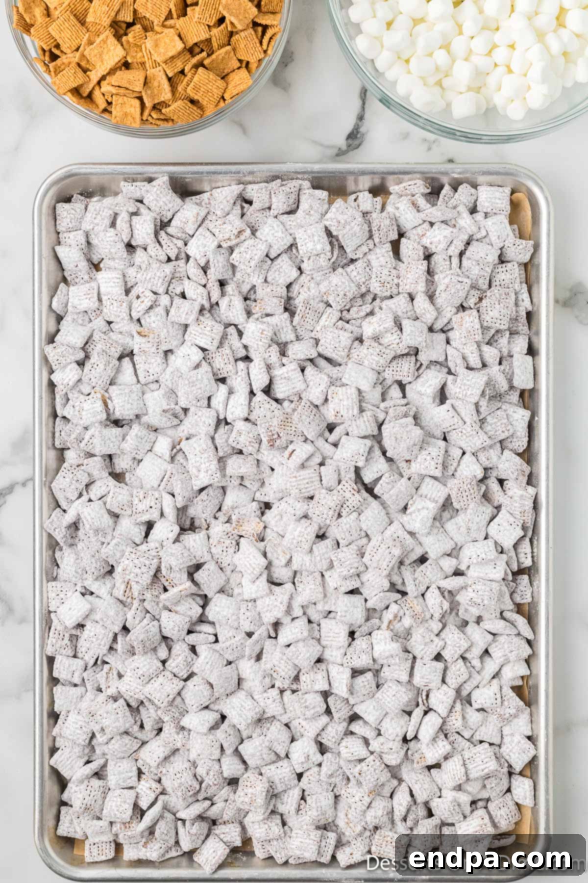 Smores Indulgence Mix 9 Freshly coated S'mores Puppy Chow spread evenly on a baking sheet to cool and set.