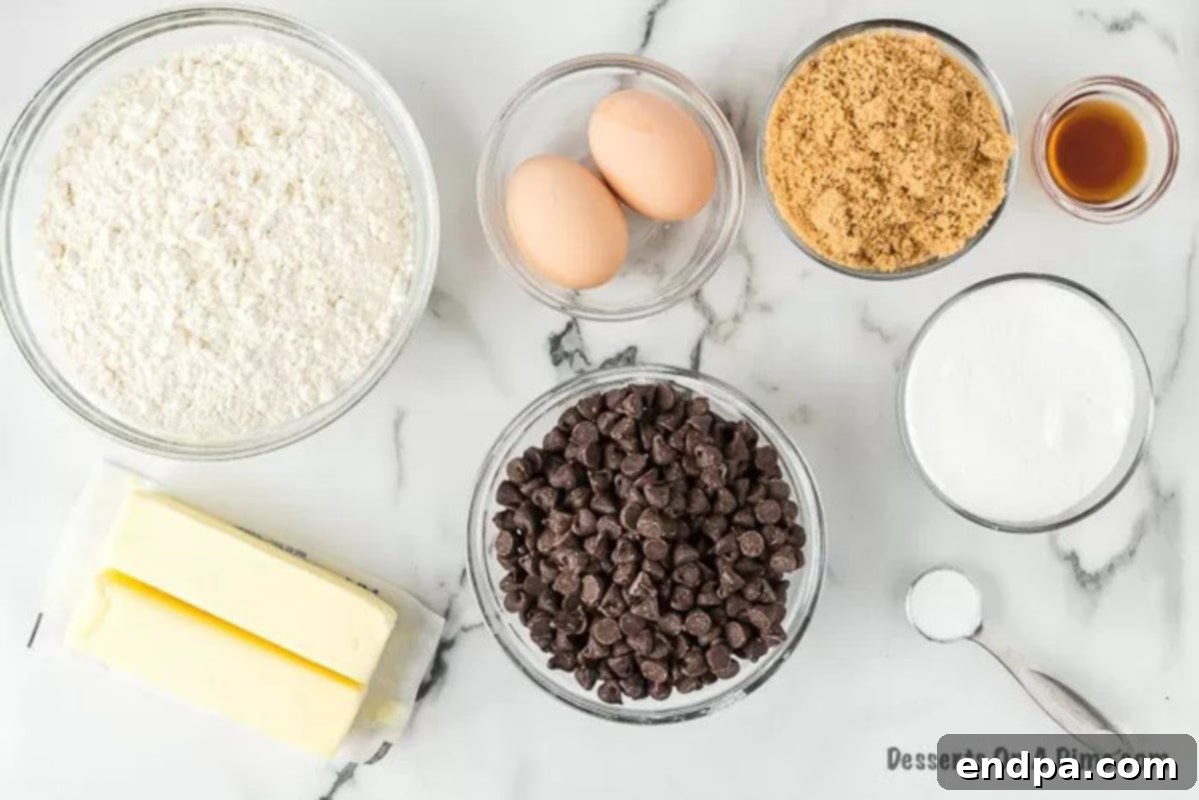Collection of pizookie ingredients laid out: butter, all-purpose flour, granulated sugar, brown sugar, baking soda, milk chocolate chips, vanilla extract, and eggs.
