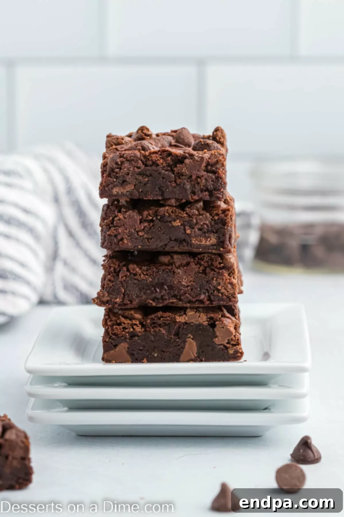 The Ultimate Brownie Doneness Test 2 Irresistible brownies stacked high on a white plate, showcasing their perfect texture and rich color.