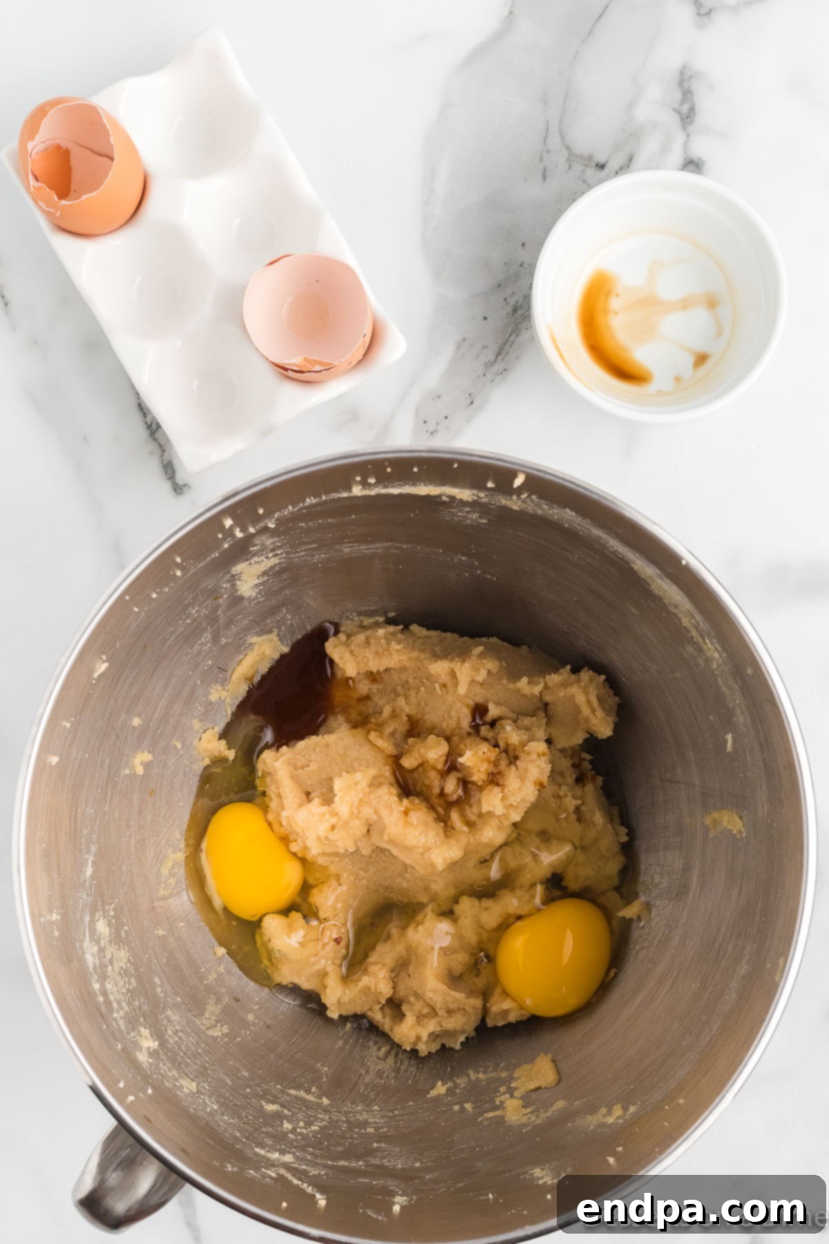 Festive Frontier Cookies 6 Adding room temperature eggs one at a time and vanilla extract to the creamed butter and sugar mixture.