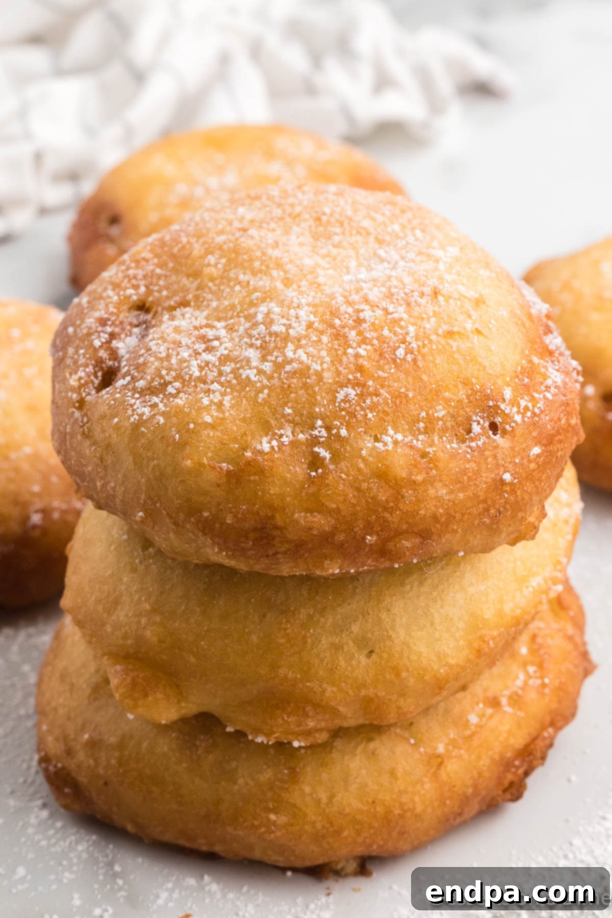 A close-up shot of a stack of freshly Deep Fried Honey Buns, golden and inviting.