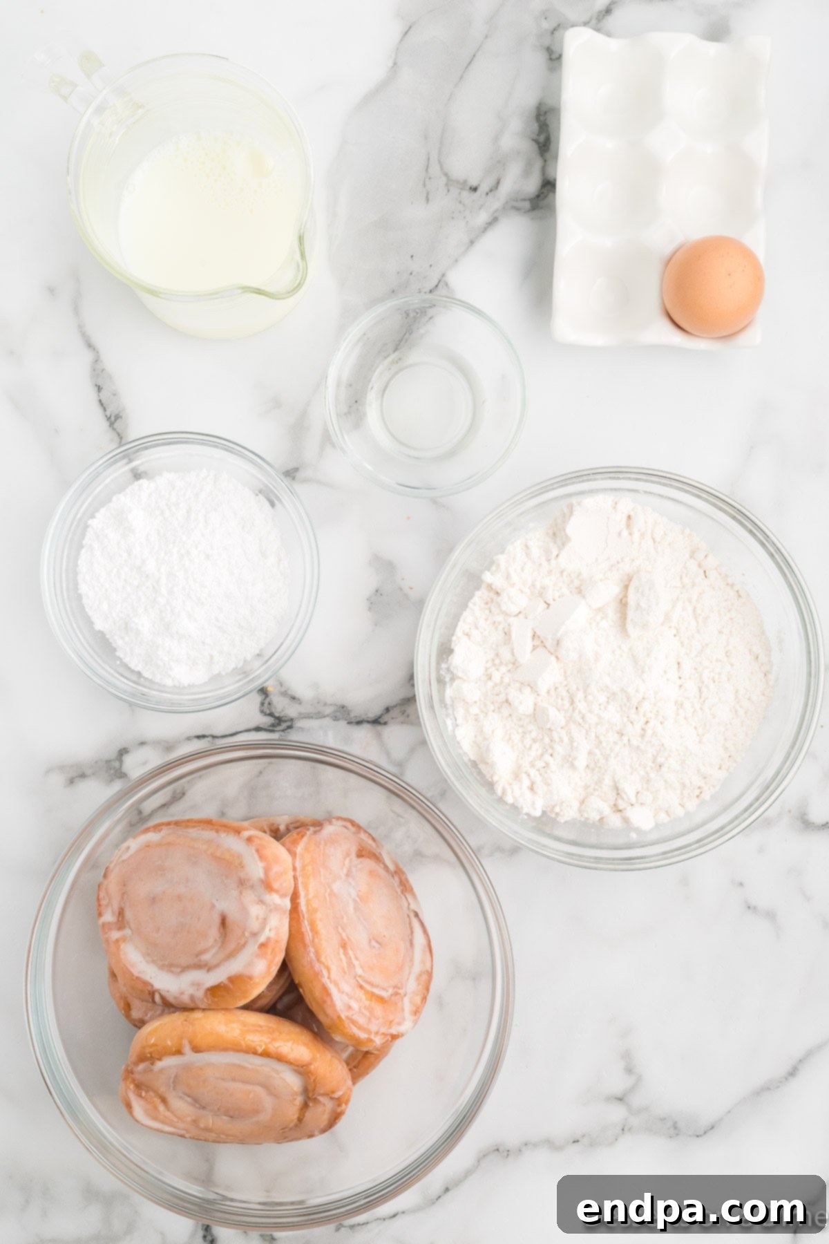 The essential ingredients for Deep Fried Honey Buns: packaged honey buns, pancake mix, a large egg, and vegetable oil.