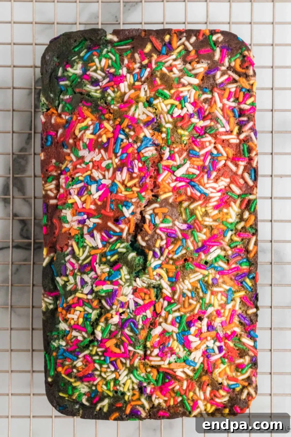 A baked loaf of unicorn bread cooling on a wire rack.