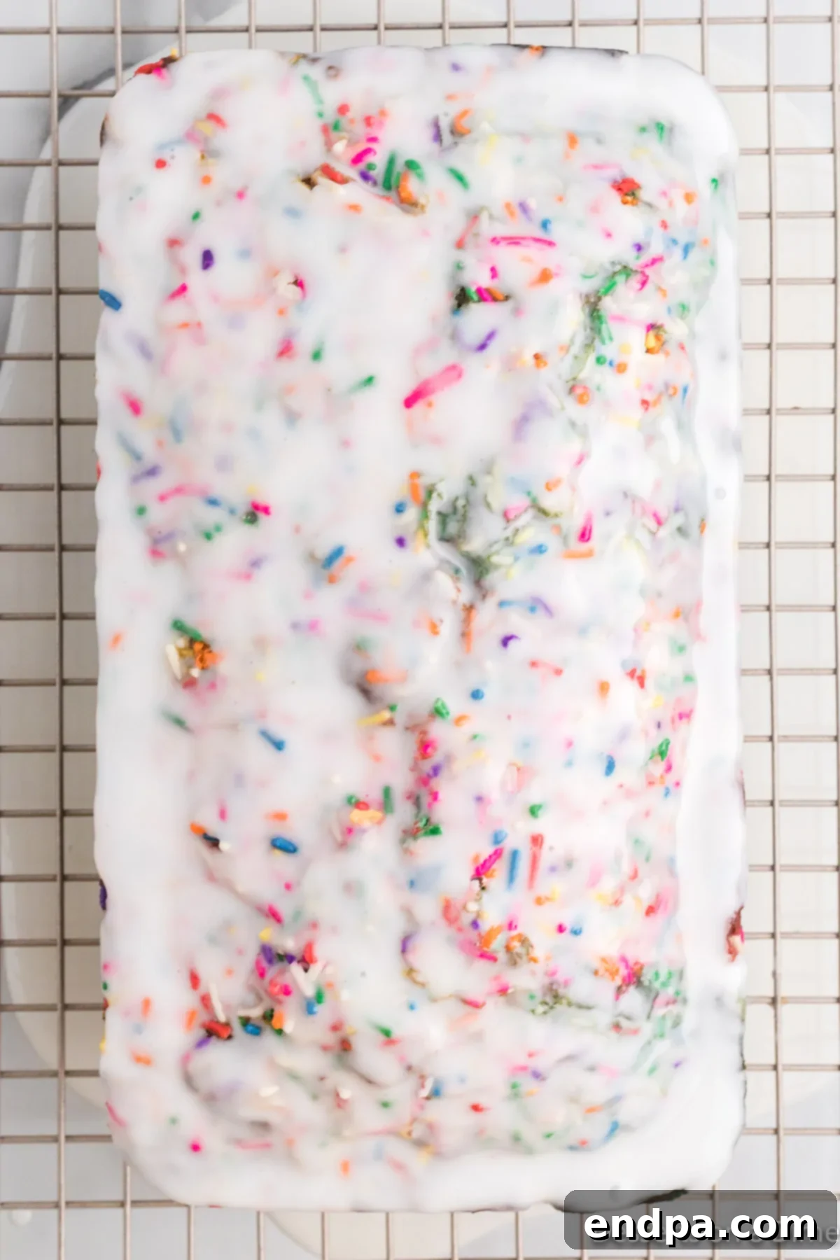 White icing drizzled over the cooled unicorn bread.