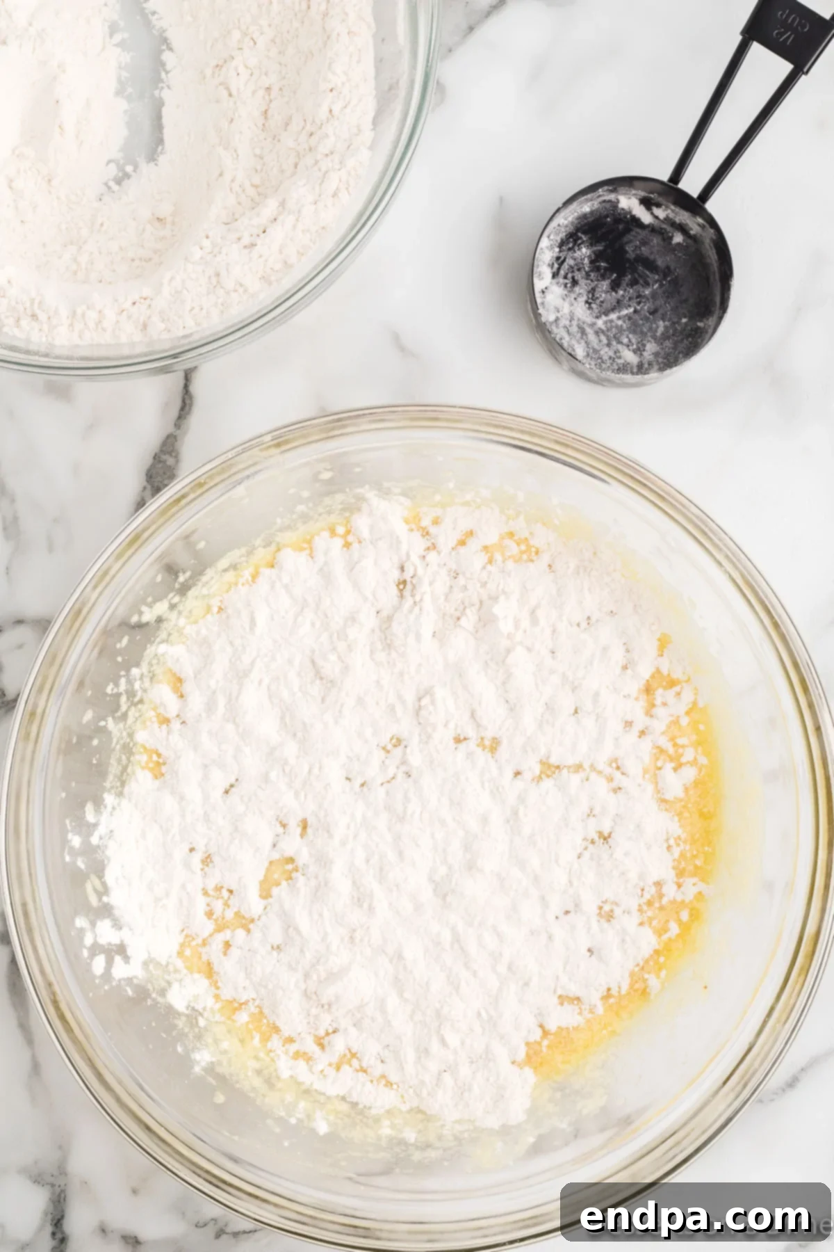 Flour mixture added to the wet ingredients in a bowl, before final mixing.