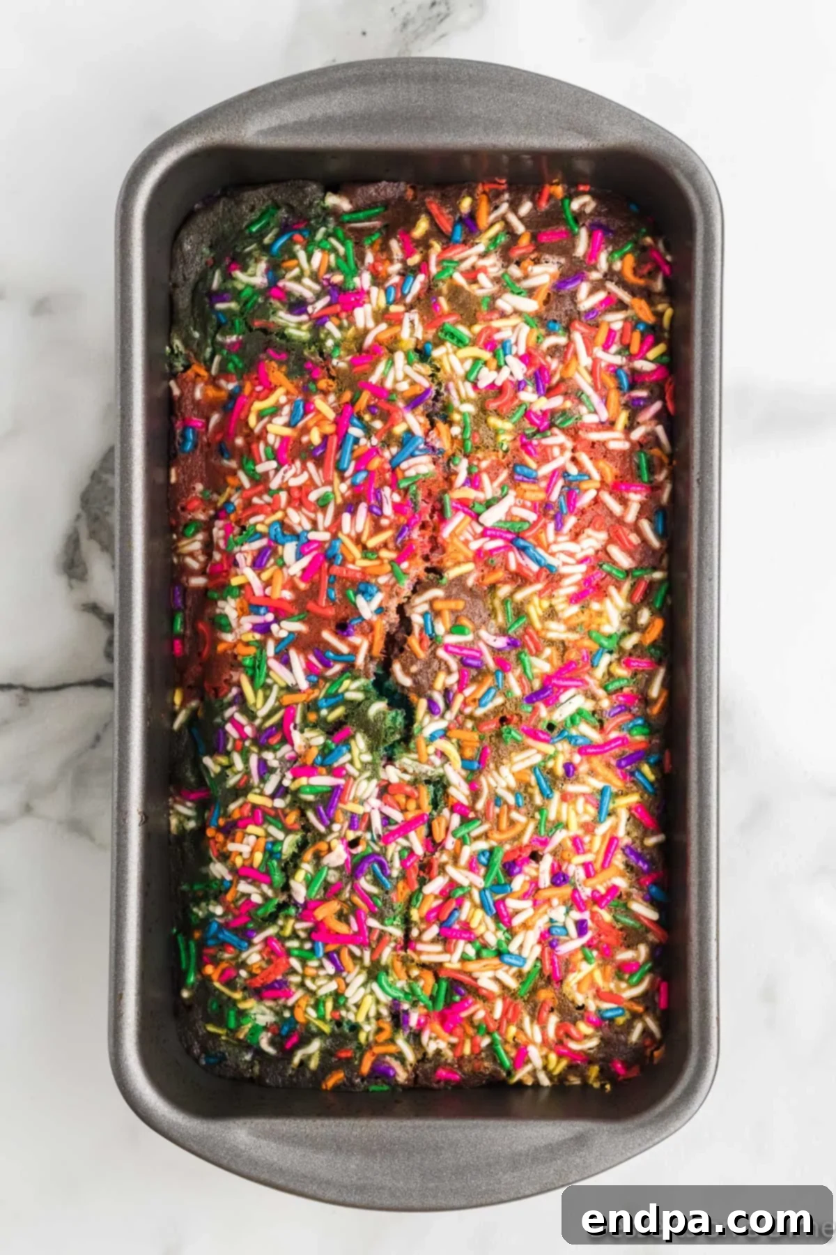 A freshly baked loaf of unicorn bread, still in the pan, cooling.