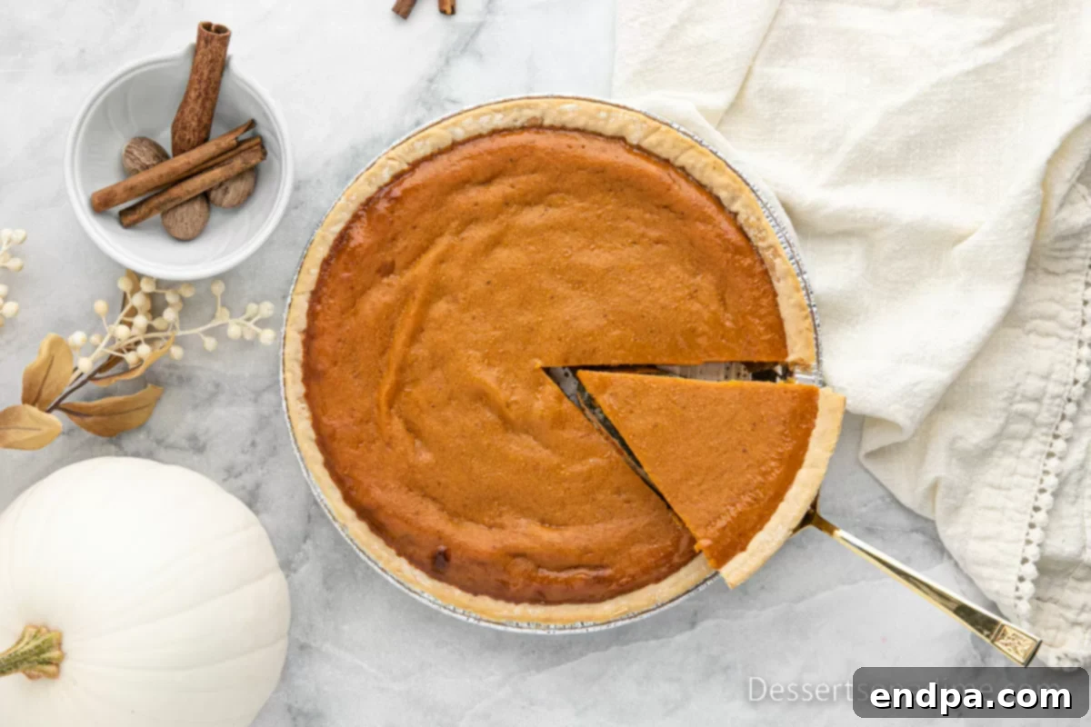 A perfectly sliced Eagle Brand Pumpkin Pie ready to be served, showcasing its creamy texture.
