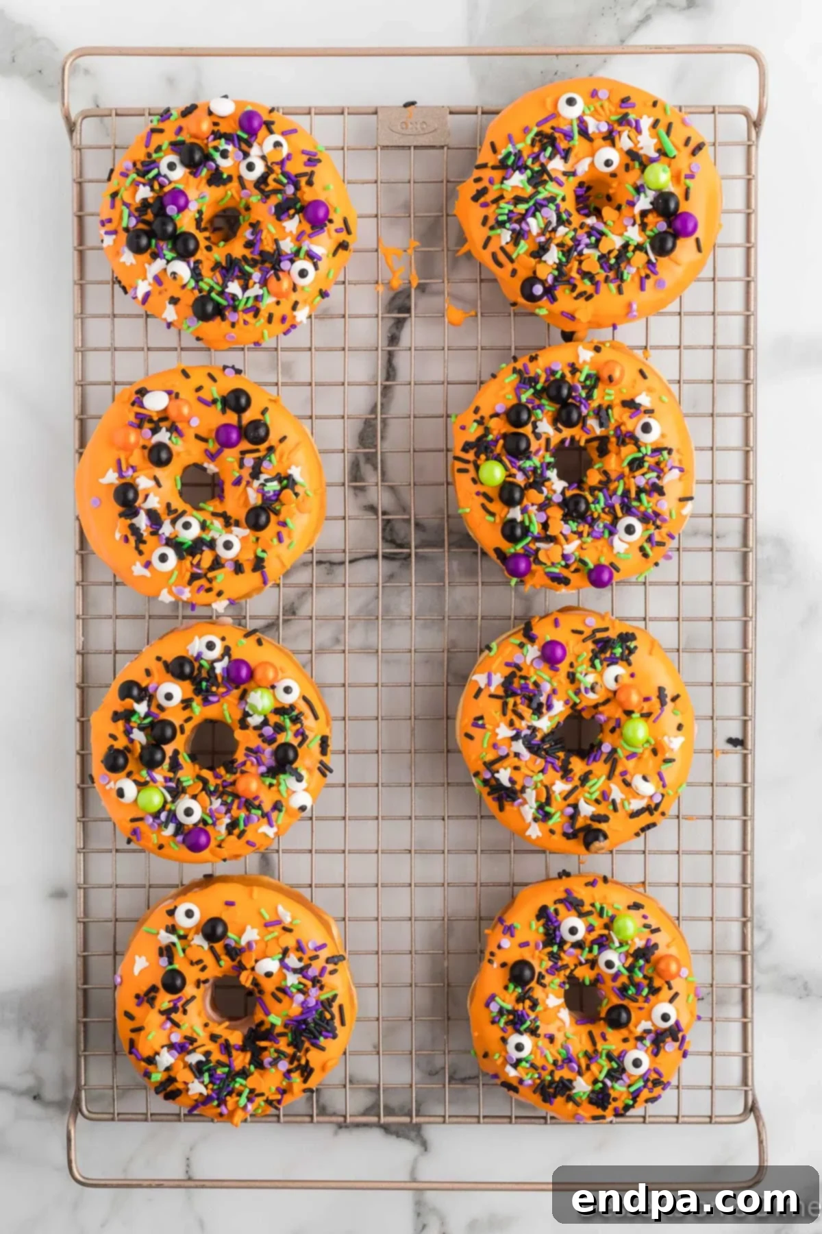 Spooky Delicious Halloween Donuts 7 Donuts on a cooling rack topped with Halloween sprinkles.