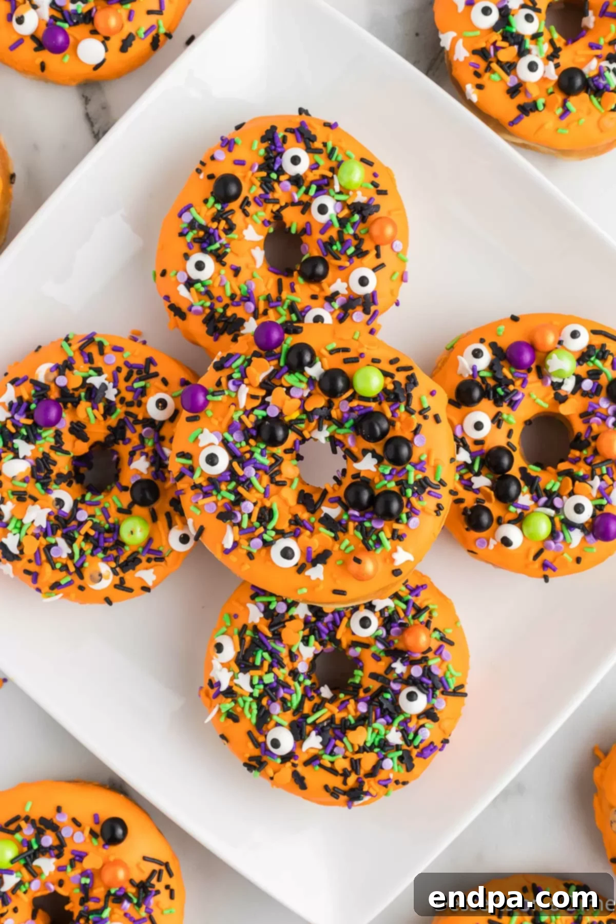 Spooky Delicious Halloween Donuts 8 Platter of decorated Halloween donuts with sprinkles and eyes.