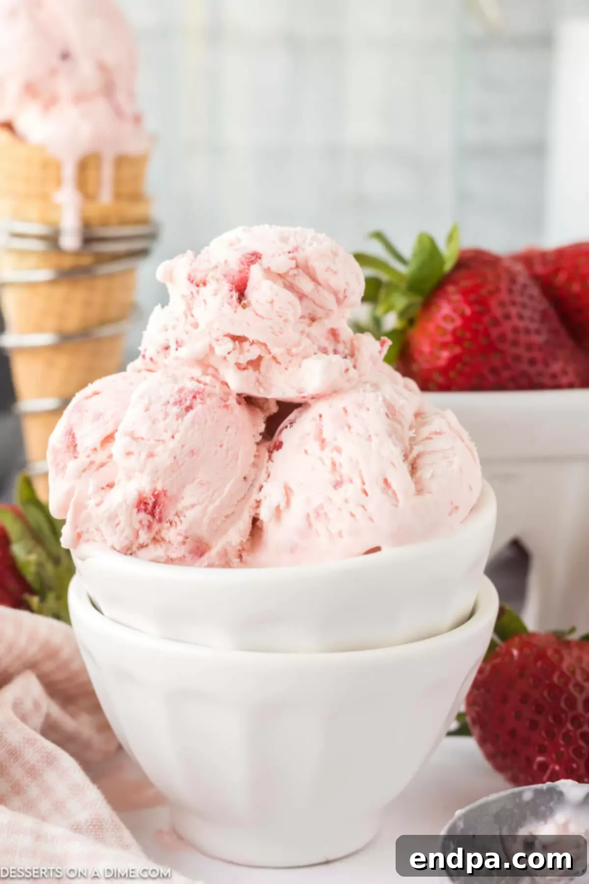 A beautifully presented bowl of No-Churn Strawberry Ice Cream with fresh strawberry garnishes.