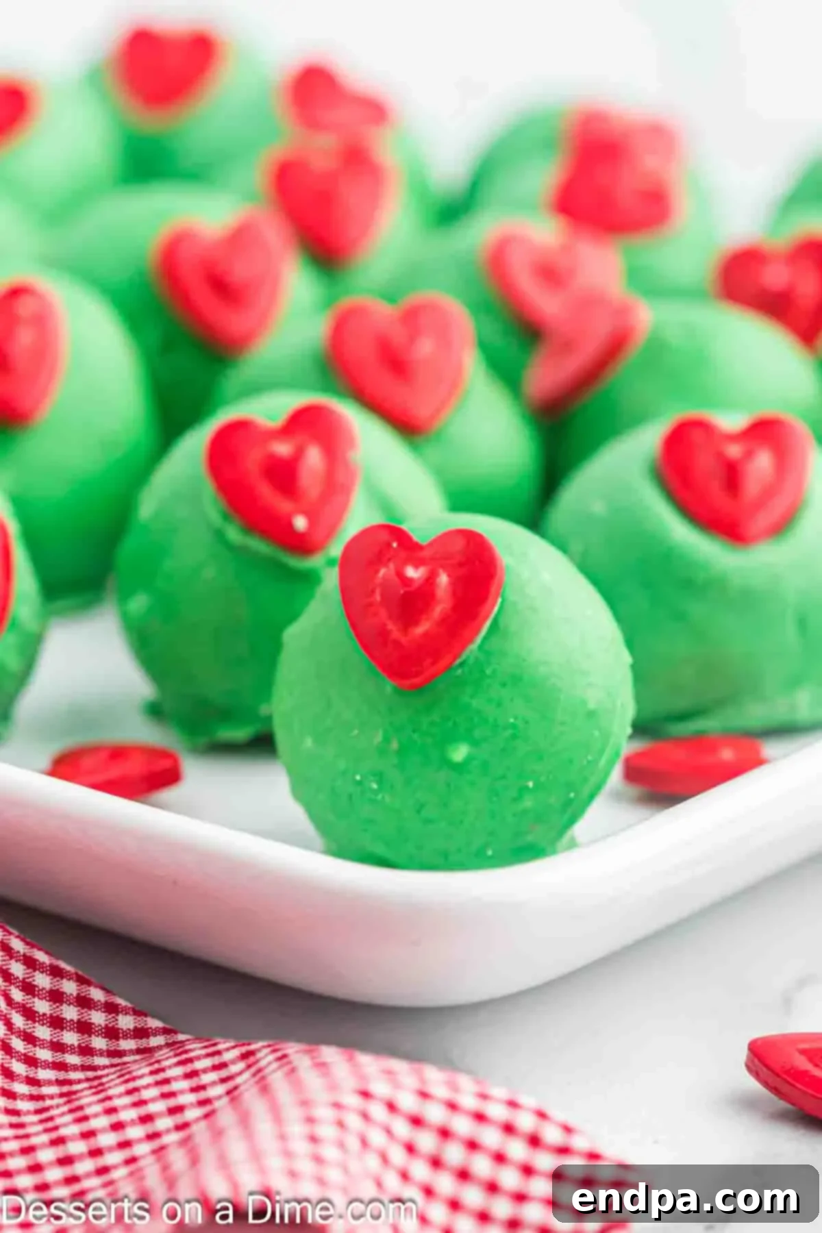 Grinchmas Cake Bites 10 A festive arrangement of Grinch Cake Balls on a decorative plate, ready to be served during the Christmas holiday.