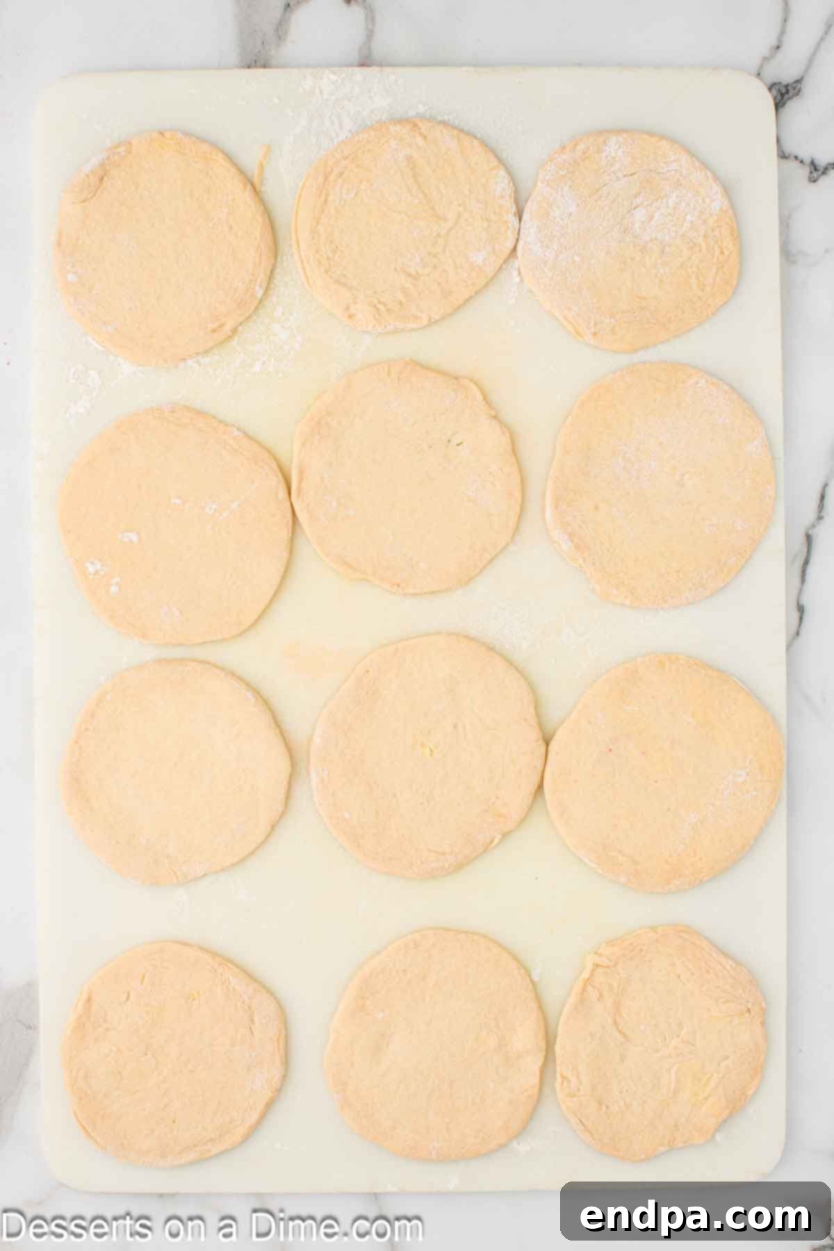 Air Fryer Apple Pie Bites 5 Separated biscuit dough pieces rolled flat into approximate 4-inch circles.