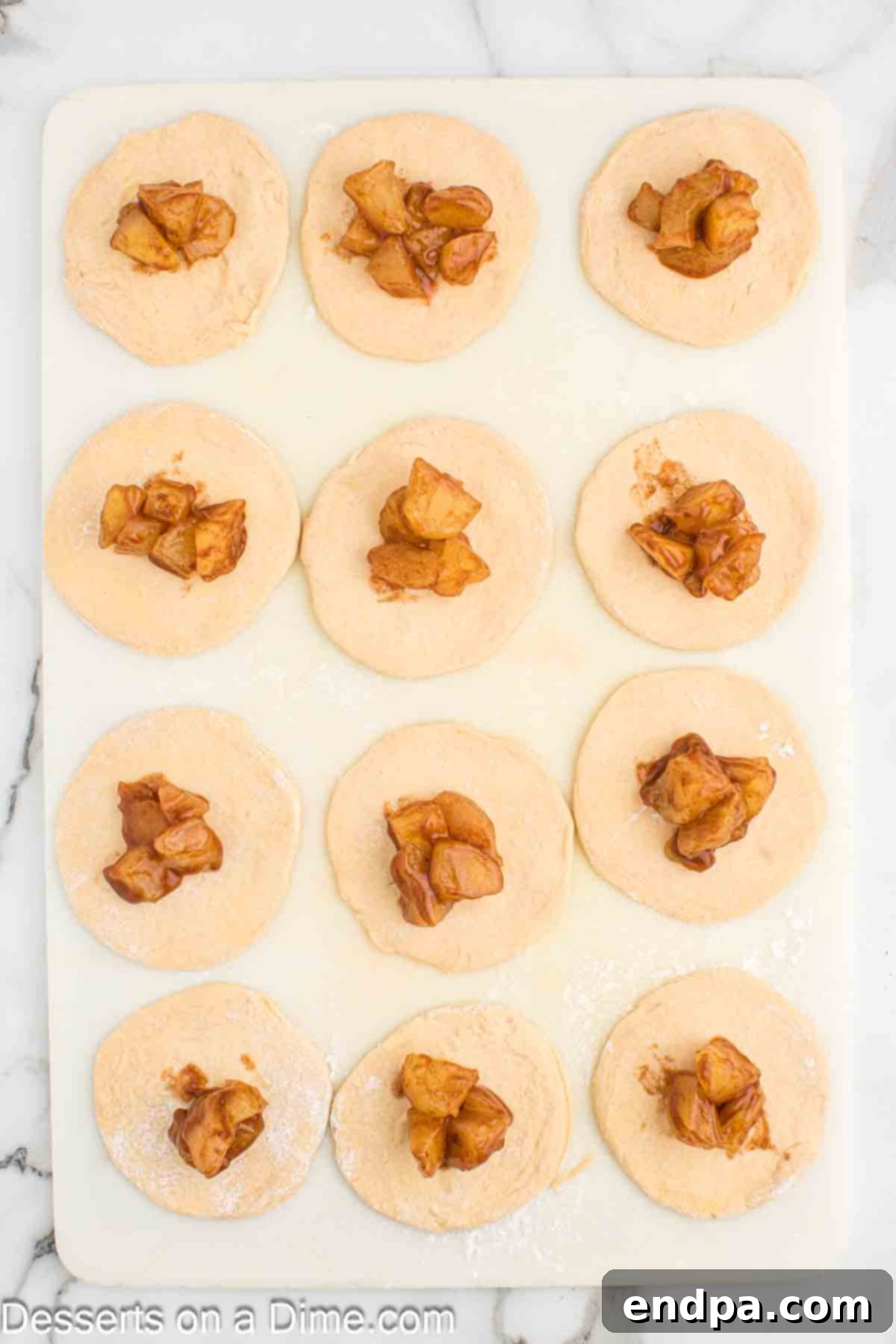 Air Fryer Apple Pie Bites 7 Small mounds of apple pie filling spooned onto the center of each rolled-out dough circle.