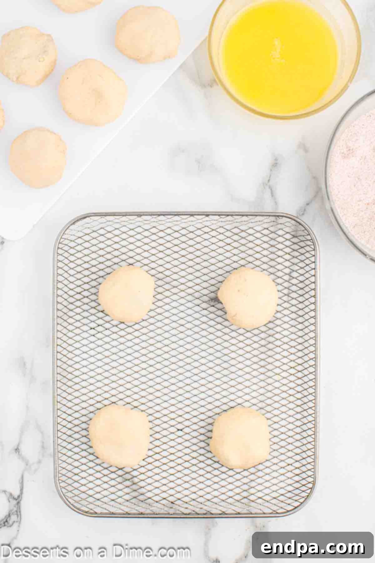 Air Fryer Apple Pie Bites 9 Several neatly rolled dough balls, filled with apple, arranged on a surface, ready for the air fryer.