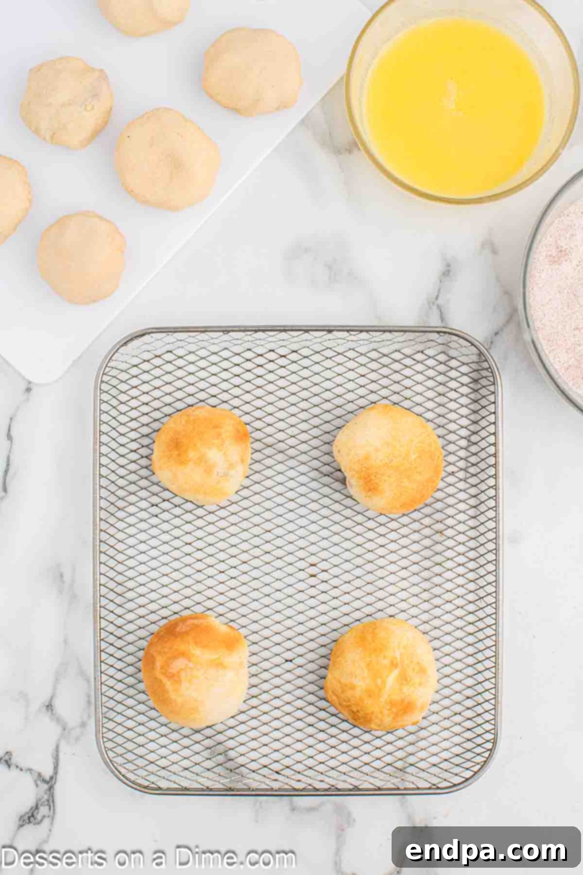 Air Fryer Apple Pie Bites 10 Cooked apple pie bombs in the air fryer basket, golden brown and puffed up.