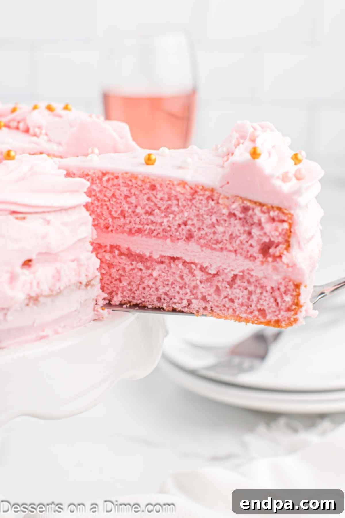 Pink champagne cake sliced on plate.