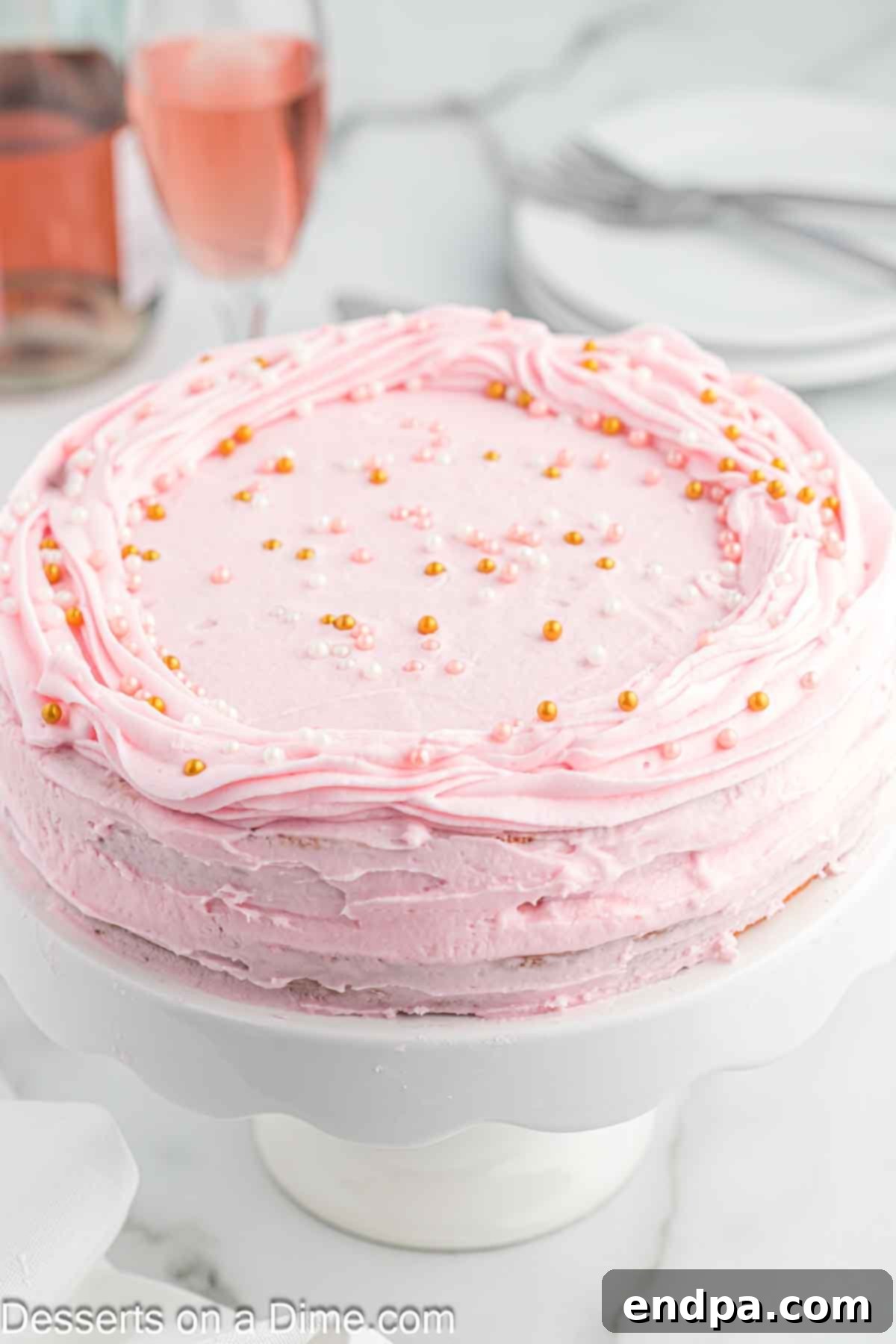 Pink champagne cake on a platter.