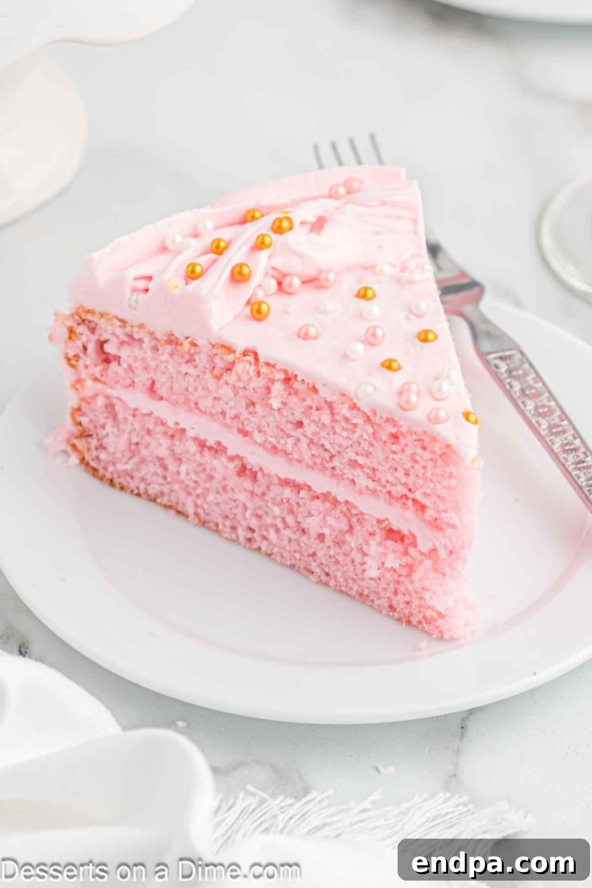 Pink champagne cake sliced on plate.