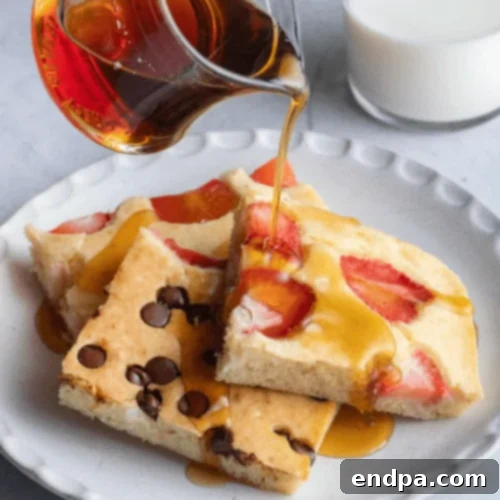 Sheet Pan Pancakes baked with various toppings, sliced for serving.