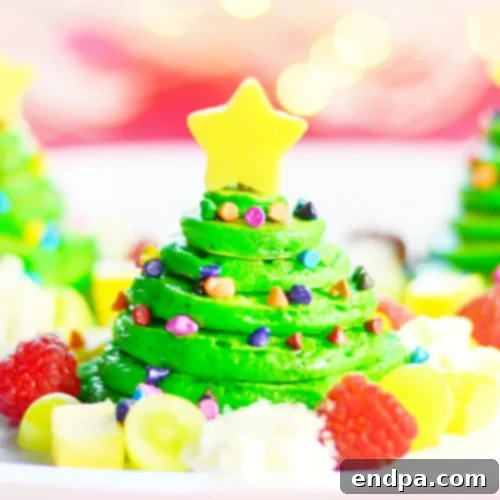 Stacked Christmas Tree Pancakes decorated with sprinkles and a star fruit.